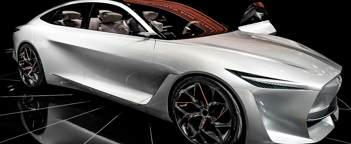 A sleek, futuristic silver car is presented on stage.