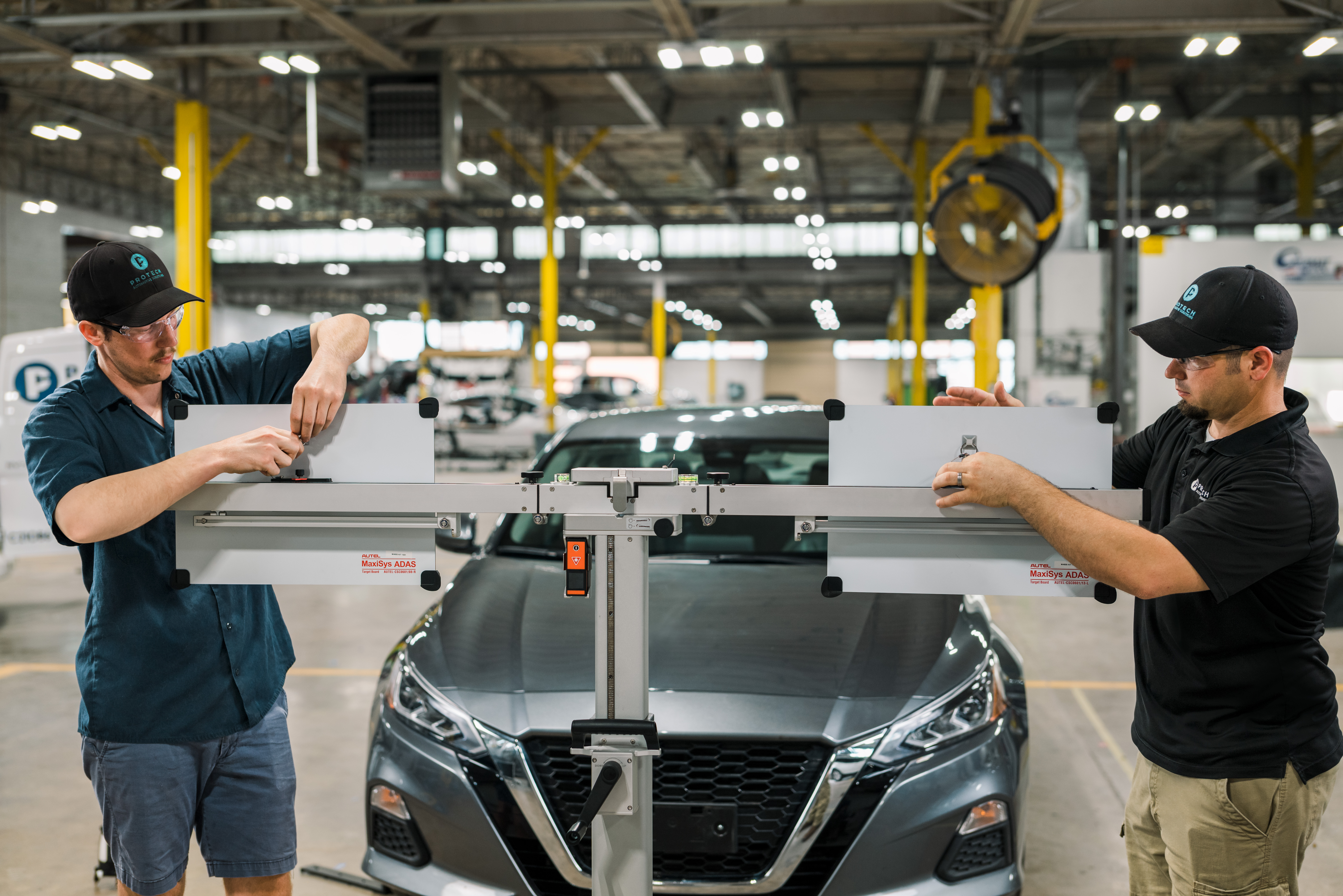 Protech Calibration Techs setting up calibration equipment to re-calibrate vehicle's ADAS.